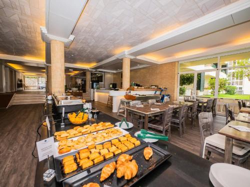 a buffet of food in a restaurant with tables and chairs at Vila Baleira Suites in Porto Santo
