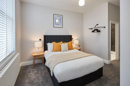 a bedroom with a large bed with orange pillows at Host & Stay - Parkside Villa in Harrogate