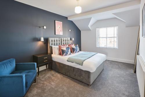 a bedroom with a bed and a blue chair at Host & Stay - Parkside Villa in Harrogate