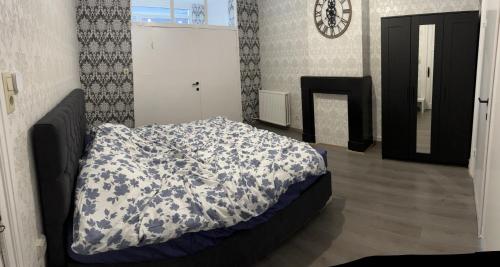 1 dormitorio con 1 cama con edredón azul y blanco en Proche de tout lieux touristiques à Liège, en Lieja