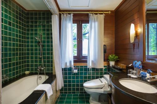 La salle de bains est pourvue d'une baignoire, de toilettes et d'un lavabo. dans l'établissement Davis Thai House, à Bangkok