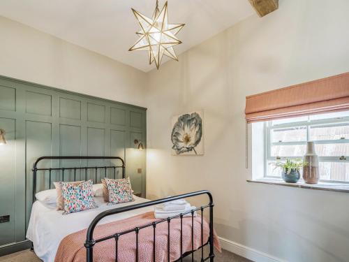 a bedroom with a bed and a star chandelier at Stables Cottage in Darlington