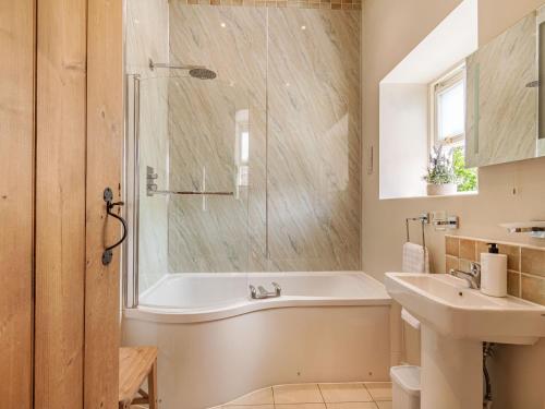 a bathroom with a tub and a sink at Stables Cottage in Darlington