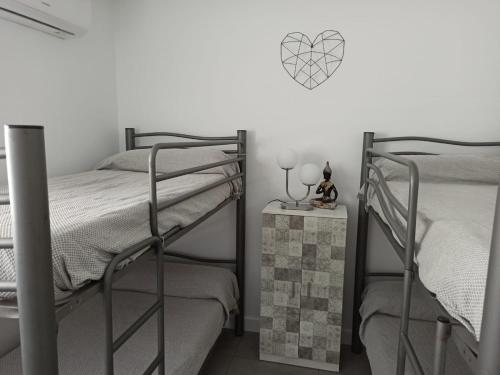 een slaapkamer met 2 stapelbedden en een tafel met een nachtkastje bij Angkor Wat Village in Puerto Real