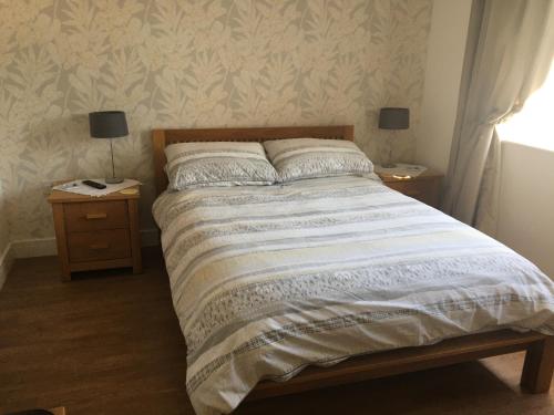 ein Schlafzimmer mit einem großen Bett mit zwei Nachttischen in der Unterkunft Hedlea in Redruth