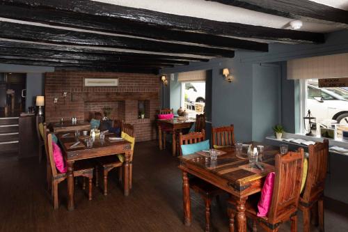 a restaurant with wooden tables and chairs and a fireplace at Queens Head Hotel in Berwick-Upon-Tweed