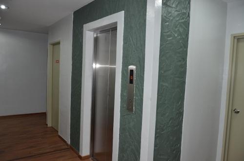 Hotel Jelai @ Raub, Pahang في راوب: مصعد في غرفة بجدران خضراء