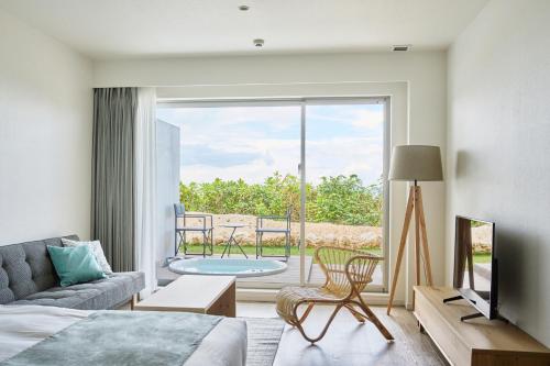 a bedroom with a bed and a view of a patio at Watermark Hotel Okinawa Miyakojima in Miyako Island