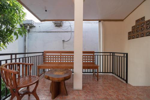 a bench and a table and a chair on a balcony at RedDoorz near RS Awal Bros Sudirman Pekanbaru in Parit