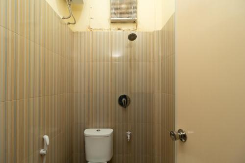 a bathroom with a white toilet in a stall at RedDoorz near RS Awal Bros Sudirman Pekanbaru in Parit