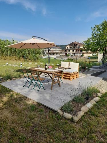 a patio with a table and an umbrella at Il Giardino di Marzo Guest House in Monti di Licciana Nardi