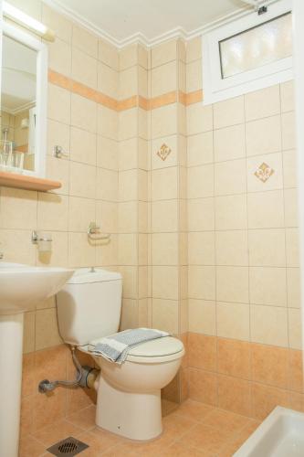 a bathroom with a toilet and a sink at BEL AIR HOTEL in Nydri