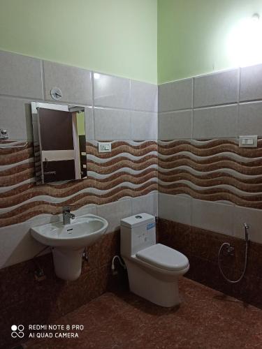 a bathroom with a sink and a toilet and a mirror at CHAMAN BASERA in Shamshi