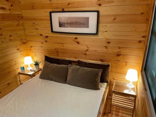 een slaapkamer met een bed in een houten muur bij Vila Paradise Bay in Smalvos