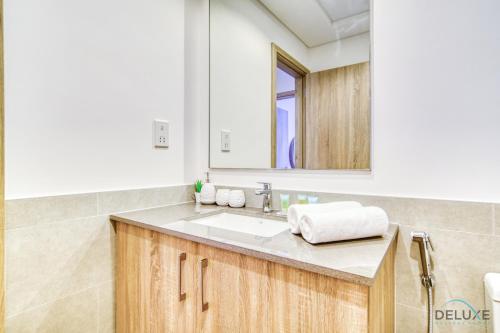 a bathroom with a sink and a mirror at Sophisticated 1BR at Town Square Rawda Dubailand by Deluxe Holiday Homes in Dubai