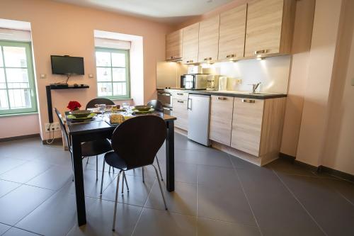 a kitchen with a table and chairs in a room at Résidence Les Rives Du Bès in Saint-Juéry