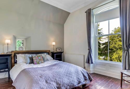 a bedroom with a bed and a large window at Fountain Hill House in Derry Londonderry