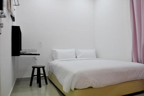 a white bedroom with a white bed and a stool at YY48 Hotel 2 Mins Walk From Masjid Jamek LRT Station in Kuala Lumpur