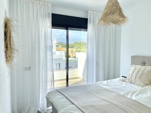 - une chambre avec un lit et une grande fenêtre dans l'établissement Penthouse in exclusive resort, à Estepona