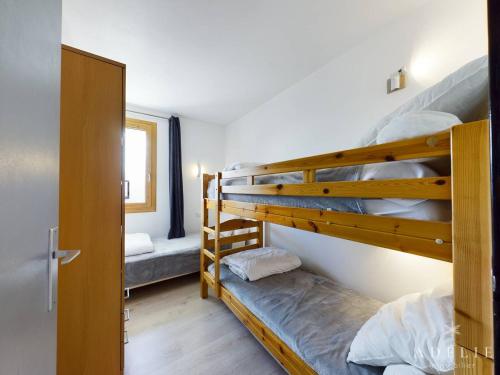 Ce dortoir comprend 2 lits superposés et une porte. dans l'établissement Appartement moderne 5 pers, skis aux pieds, parking inclus - FR-1-398-567, à La Rosière