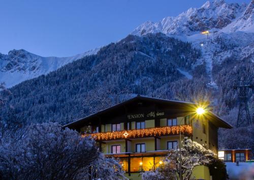 a large building with a mountain range at Café Pension Alpina in Innsbruck