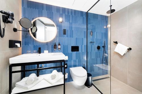 a bathroom with a toilet and a sink and a mirror at Three Corners Downtown Hotel in Budapest