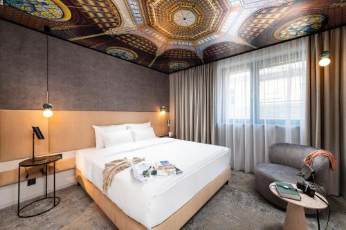 ein Schlafzimmer mit einem großen Bett und einer Kassettendecke in der Unterkunft Three Corners Downtown Hotel in Budapest