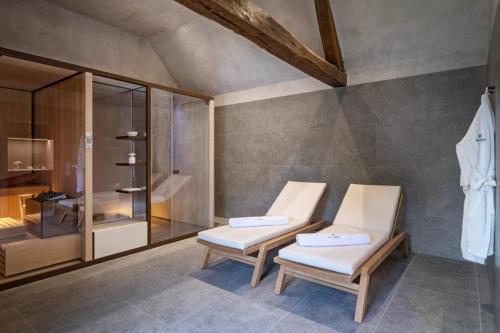 - deux chaises blanches dans une chambre avec douche dans l'établissement Chateau de Wallerand, à Vireux-Wallerand