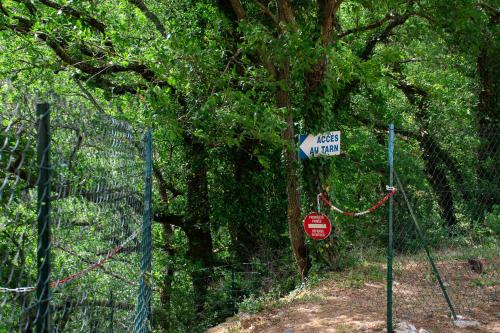 a street sign and a stop sign next to a fence at Village de gîtes de Blajoux in Quézac