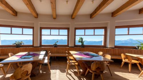 a dining room with tables and chairs and windows at Café Pension Alpina in Innsbruck