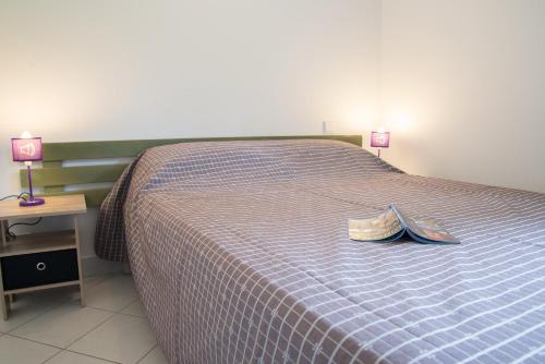 a bedroom with a bed with a pair of shoes on it at Village de gîtes de Blajoux in Quézac
