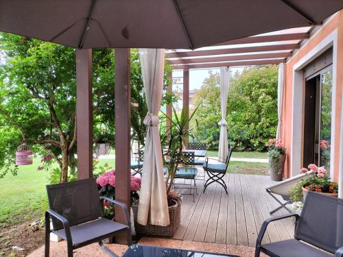 a patio with chairs and a table and an umbrella at B&B Terre Di Bea in Pederobba