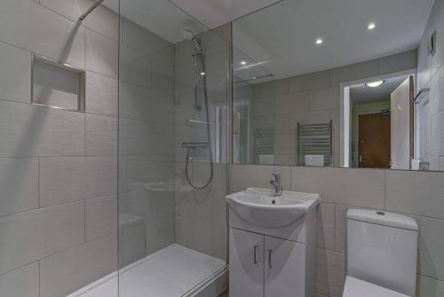 uma casa de banho com um chuveiro, um WC e um lavatório. em * Stunning City Centre Penthouse Over Two Floors * em Manchester