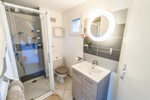 a bathroom with a shower and a toilet and a sink at Village de gîtes de Blajoux in Quézac