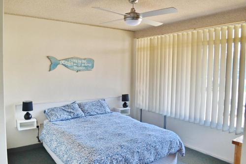 a bedroom with a bed and a ceiling fan at Wards Holiday Flat 3 in South West Rocks