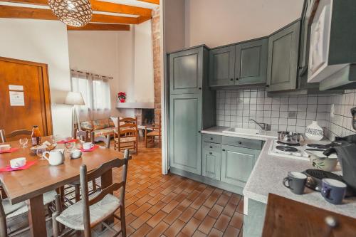 a kitchen with green cabinets and a wooden table at Village de Gîtes de Chanac in Chanac