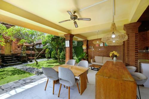 a living room with a wooden table and chairs at Jero Delod Guesthouse in Tabanan
