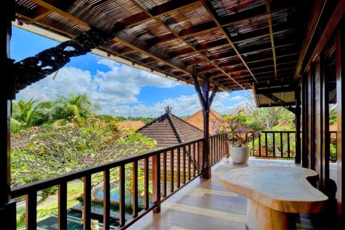 a balcony with a table and a view of the ocean at Jero Delod Guesthouse in Tabanan