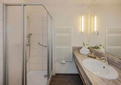 a bathroom with a sink and a shower at Vineta Haus Schwalbe in Zempin