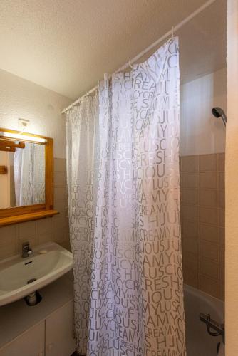 une salle de bain avec un rideau de douche et un lavabo dans l'établissement Appartement Chabrières, à Réallon