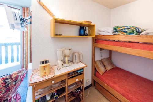 a small room with two bunk beds and a desk at Appartement Chabrières in Réallon