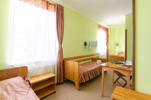Schlafzimmer mit einem Bett, einem Schreibtisch und einem Fenster in der Unterkunft Тиса Економ in Kiew