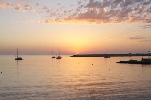 a group of boats in the water at sunset at VILLA ROSA MEDITERRANEA in Marina di Pescoluse