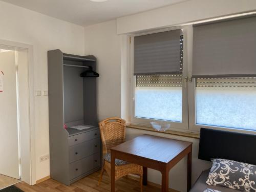 Habitación pequeña con mesa y 2 ventanas en Monteurunterkunft, en Kleve