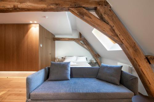 a blue couch in a room with a bed at Chateau de Wallerand in Vireux-Wallerand