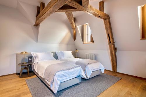 two beds in a attic bedroom with wooden beams at Chateau de Wallerand in Vireux-Wallerand