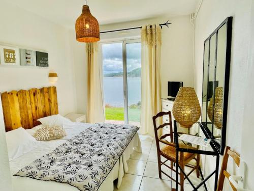 1 dormitorio con cama y vistas al océano en La Caravelle Logis, en Biscarrosse