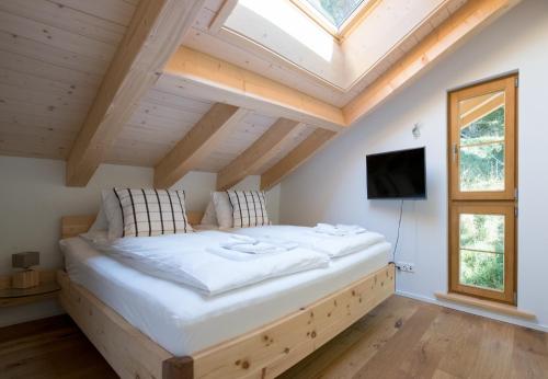 a large bed in a room with a skylight at Panoramapark Soleil Chalet E in Wengen