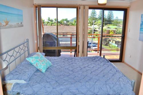 a bedroom with a bed and a view of a balcony at Paragon Apartment 8 in South West Rocks