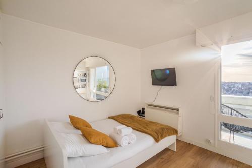 Cette chambre blanche comprend un lit et un miroir. dans l'établissement BALCON DU CANAL - Studio lumineux avec balcon au bord de la Vilaine et de lhyper centre-ville, à Rennes